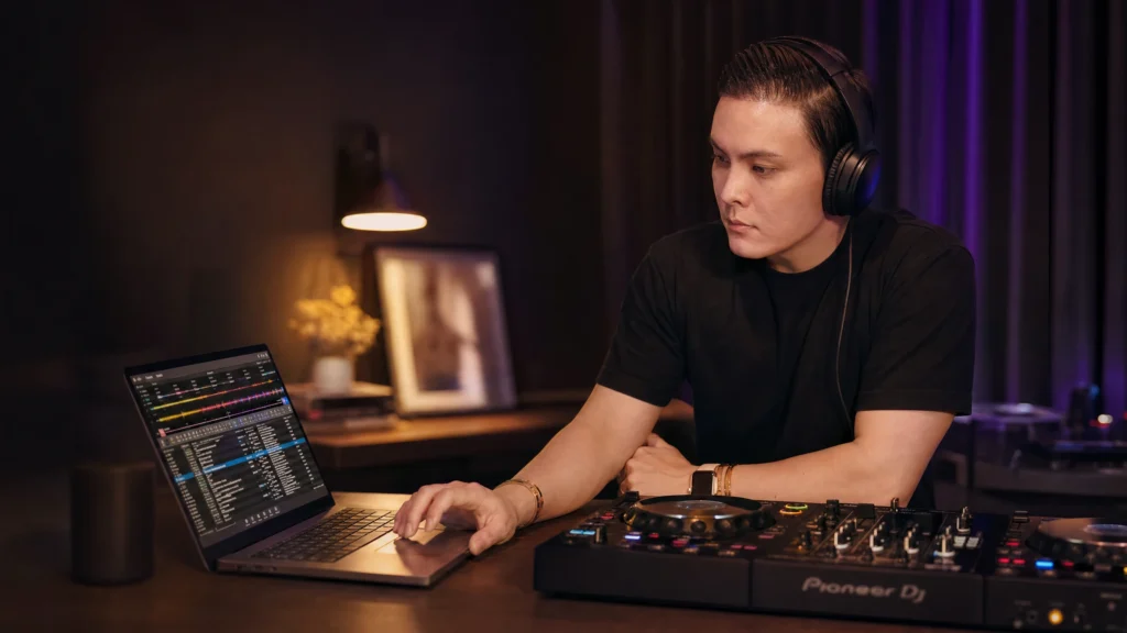 DJ planning and building a set on a laptop with a controller