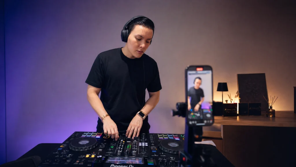 DJ filming a performance clip for social media in a home studio
