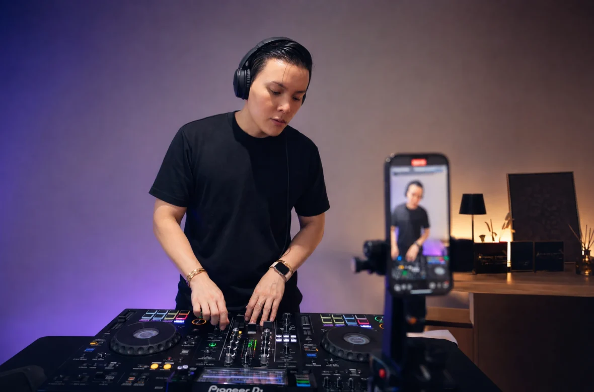 DJ filming a performance clip for social media in a home studio