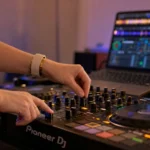DJ hands on the crossfader and EQ mixing two songs together