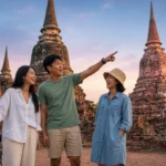 Young Thai friends with bicycles exploring ancient temple ruins in Ayutthaya at golden hour