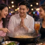 Young Thai friends chatting and smiling at a Bangkok street-food stall at night