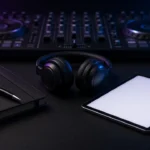 DJ controller, headphones, notebook and pen on a dark booth desk ready for booking paperwork
