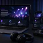 Laptop and smartphone showing a dark DJ website layout beside a DJ controller and headphones